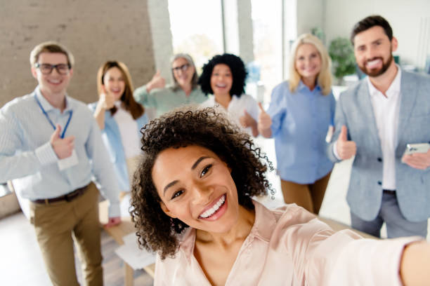 istock Diverse team of professionals in an office taking a cheerful group selfie 2202228275