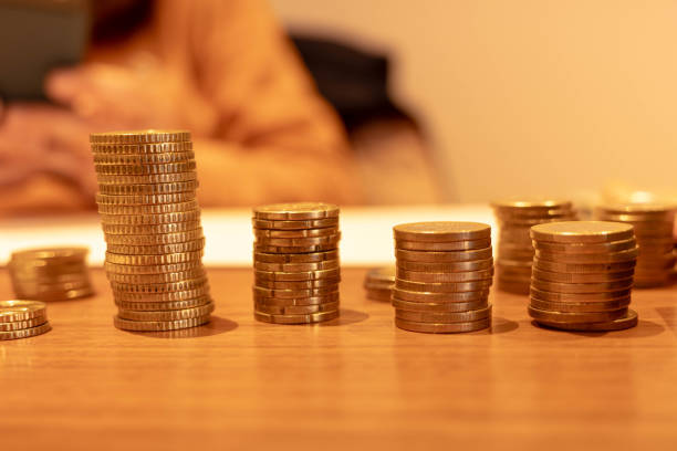 The image showcases neatly arranged stacks of coins varying in height, representing organization, wealth accumulation, and financial growth on a wooden surface.