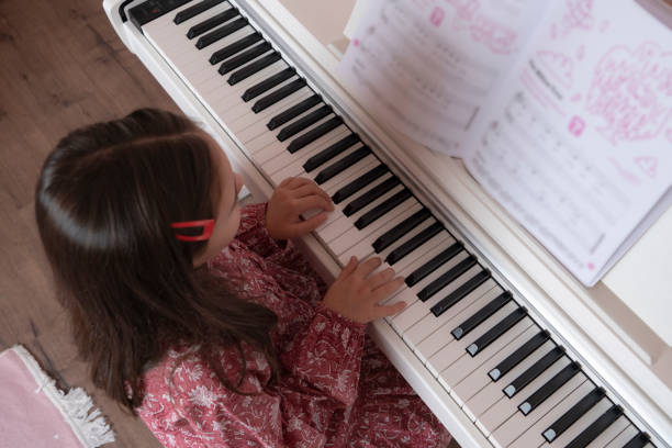 istock Little happy girl playing piano. 2202228642