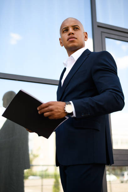 istock Low angle view of african american manager holding documents near building 2202230658