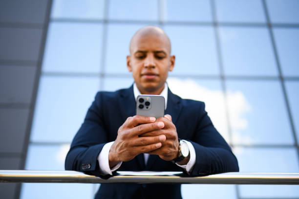 istock Blurred african american businessman using smartphone on street 2202230839
