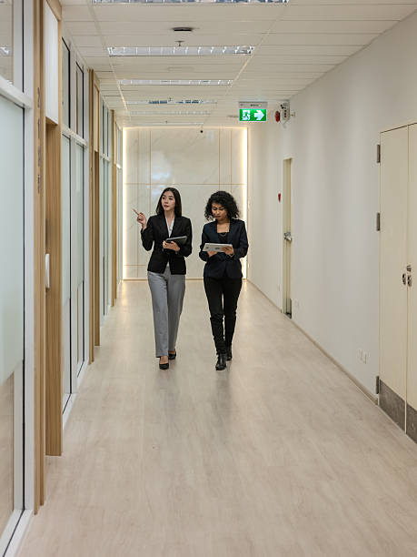 istock Two business professionals walking together in a modern office 2202231290