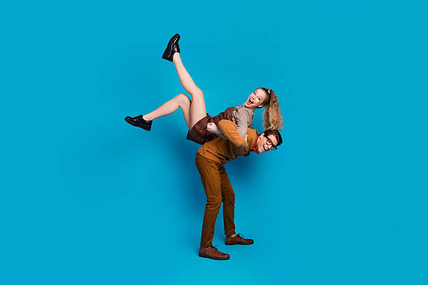 istock Couple having fun in a creative playful pose against a blue background 2202231950