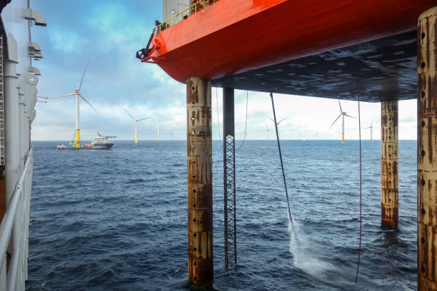istock Service Jack-Up Vessel Support Operations Offshore and Wind turbine Service vessel with helipad and in Action. Dramatic sky and wavy sea. 2202232451