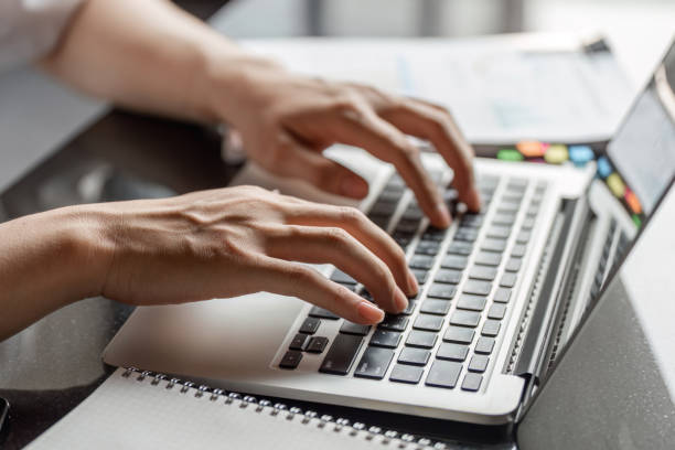 istock Close-up of young professional's hands typing on laptop keyboard while working on financial analysis. 2202236765