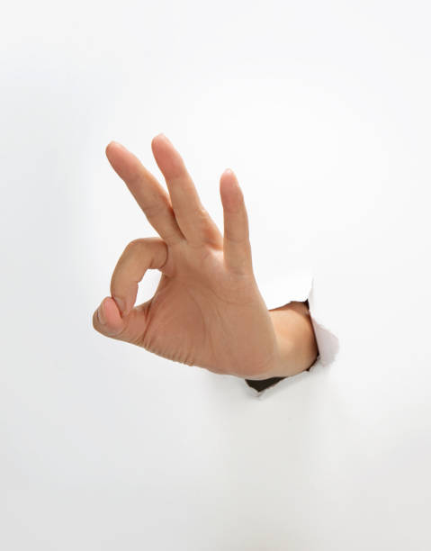 istock Ok Gesture through the hole in paper sheet 2202237277