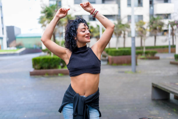 istock Young latin woman dancing in the city 2202238043