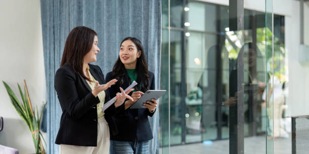 istock Two businesswomen engaged in a lively discussion about strategies while using a tablet in a contemporary office. 2202238107