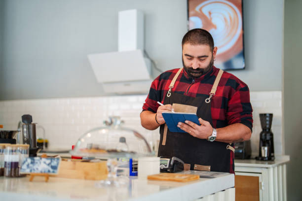 istock Barista using digital tablet behind the counter at coffee shop. 2202241096