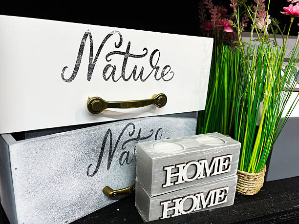 istock Decorative storage boxes with 'Nature' text and 'Home' block during floral arrangement. 2202241511