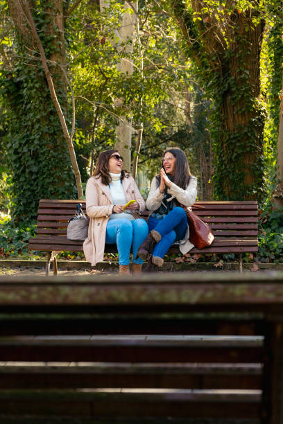 istock Two mature women having fun outdoors using smartphone 2202257094
