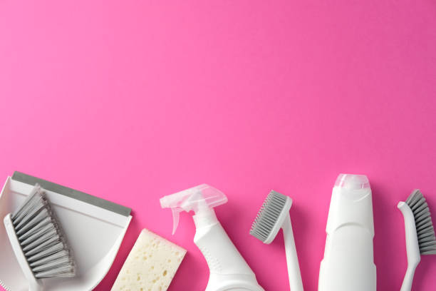 istock Cleaning tools on a pink background, top view. Flat lay composition with dustpan, brushes, sponge, spray bottle, and detergent bottle. Ideal for household cleaning themes 2202260823