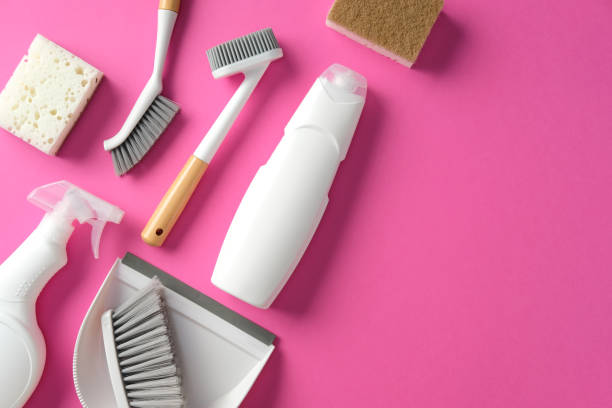 istock Eco-friendly cleaning supplies on a pink background. Includes brushes, sponges, spray bottle, and detergent. Household cleaning and hygiene concept 2202260891