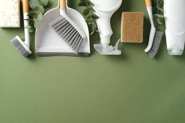 istock Flat lay cleaning supplies on green background. Includes brushes, dustpan, spray bottle, sponge, and eucalyptus leaves. Ideal for eco-friendly cleaning themes 2202260952