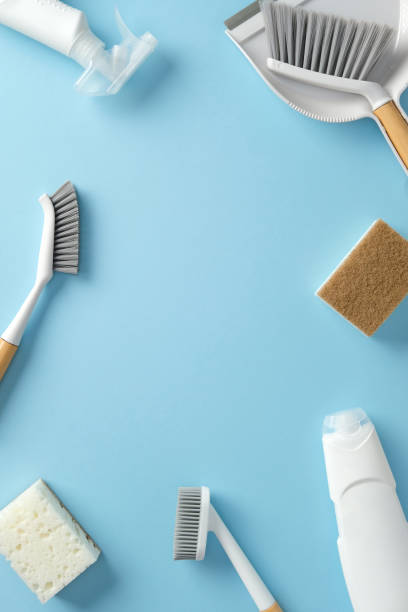 istock Frame of cleaning tools on blue background. Top view brushes, sponge, scrubber, and dustpan. Perfect for household cleaning themes 2202260994