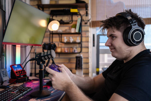 istock Professional gamer streaming live, playing videogames competitively at home 2202262601