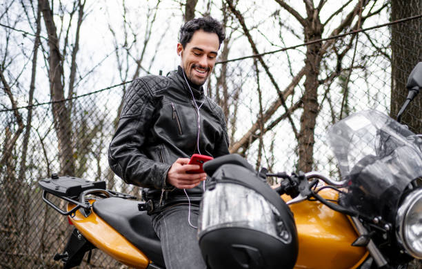 istock Young man using the phone on a motorbike 2202266936