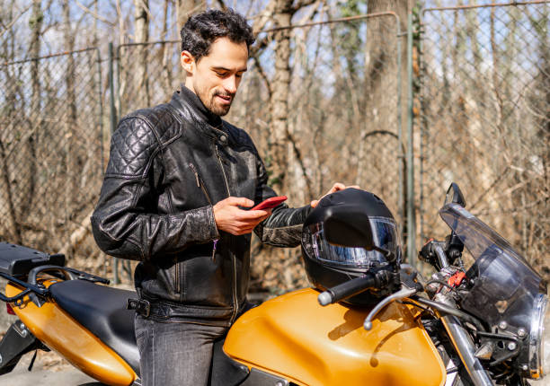 istock Young man using the phone on a motorbike 2202266962
