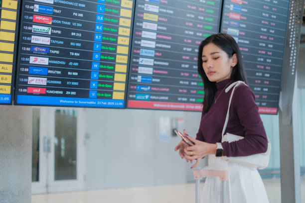 istock Asian woman waiting for plane and checking her flight schedule 2202268220