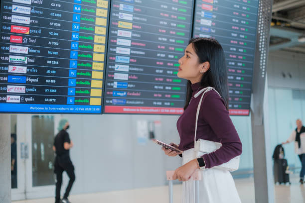 istock Asian woman waiting for plane and checking her flight schedule 2202268234