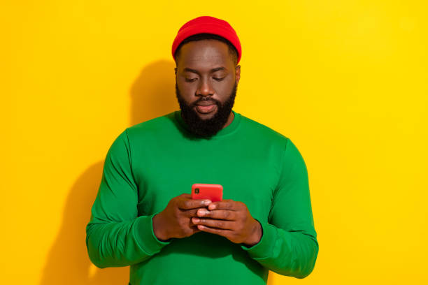 istock Portrait of attractive focused guy using device gadget chatting post smm isolated over bright yellow color background 2202270885