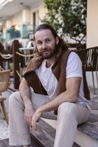 istock Relaxed man sits casually on steps in a modern outdoor space on a sunny day 2202272624