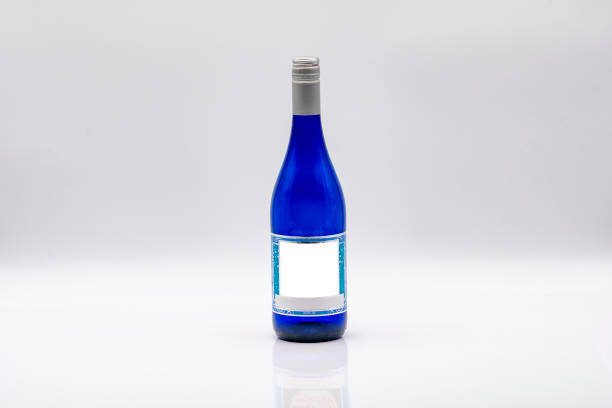 Unique Blue Glass Bottle With a White Label on a Minimalist Background