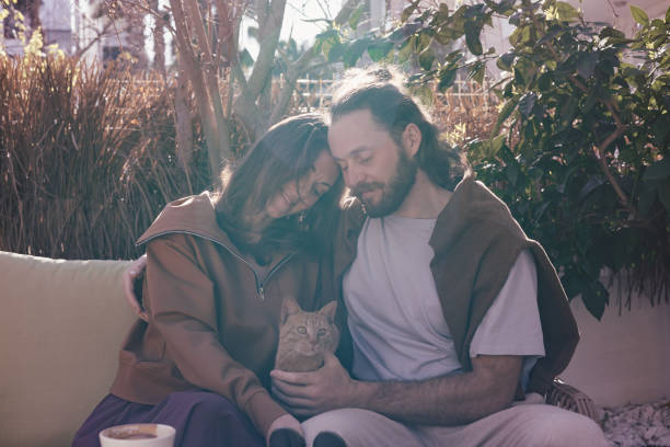 istock Romantic couple sharing a kiss in a sunlit outdoor cafe setting 2202274498