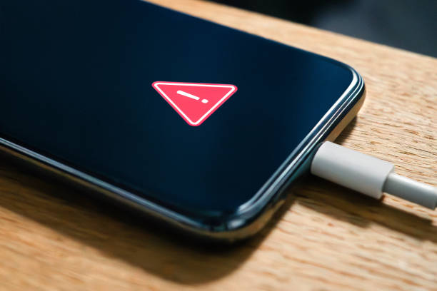 Phone battery charge error and problem. Charger usb cable issue. Overheating or low performance recharge in smartphone. Hot lithium mobile damage safety warning. Cellphone crash. stock photo