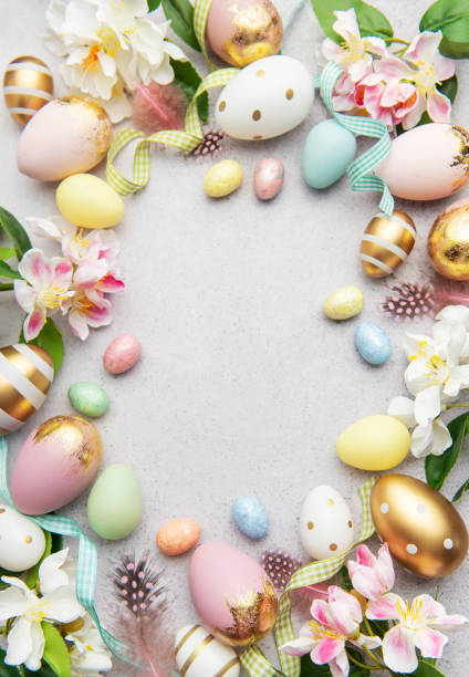istock Easter eggs frame forming a circle on a gray background with flowers and feathers 2202281525