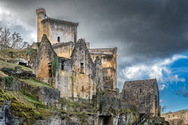 Eyzies, Dordogne, France - 25th February 2025: Dark storm clouds hang over the medieval 12th century Chateau de Commarque in the Dordogne region of France