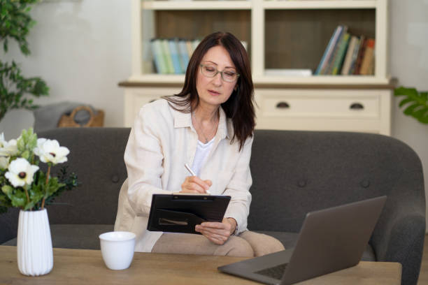 istock Thoughtful woman working on a tablet in cozy living space 2202282010