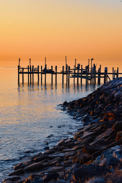 istock Dawn sky over a Chesapeake Bay pier and rock abutment 2202289389