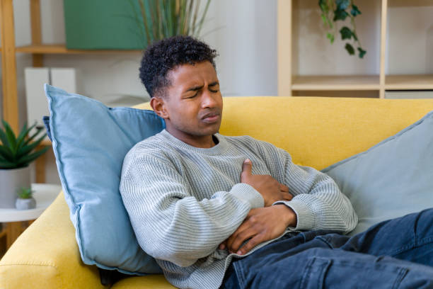 istock man suffering from stomach ache lying on sofa 2202291658