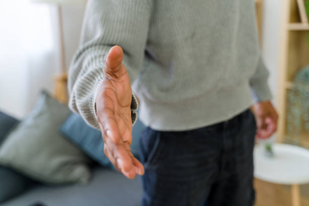Businessman extending hand for handshake, welcoming a new client or employee in the home office
