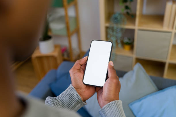 istock Man relaxing on sofa holding smartphone with blank screen 2202292262