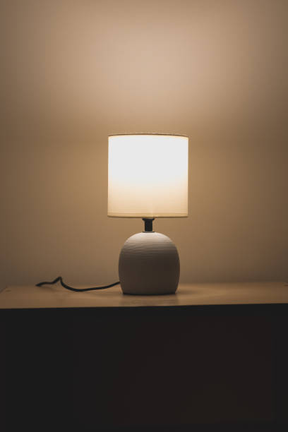 istock Modern night table lamp. Warm lighting from bedside lamp for reading books. Vertical photo. 2202292926