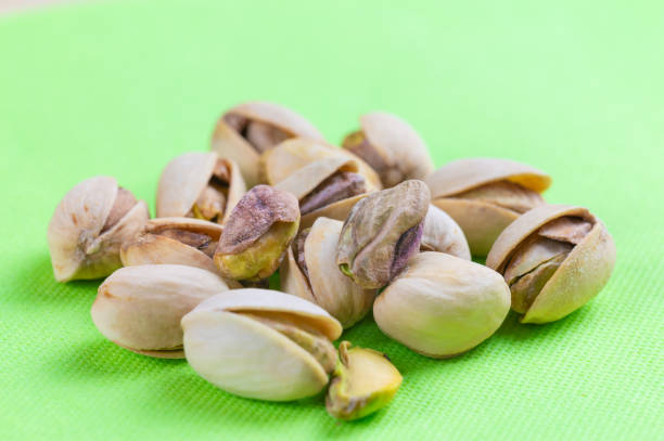 istock Pistachios in shell in white bowl. 2202294493