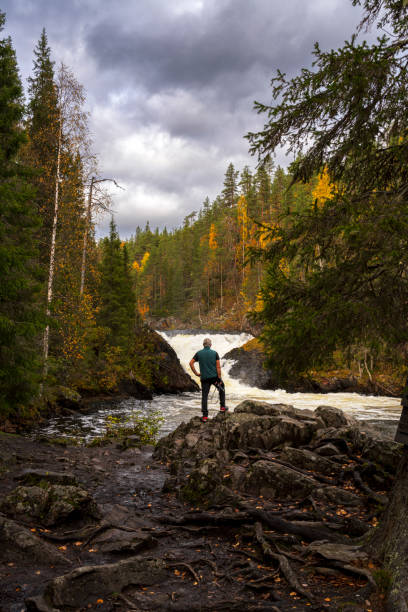istock Man admiring waterfall in autumn 2202298735