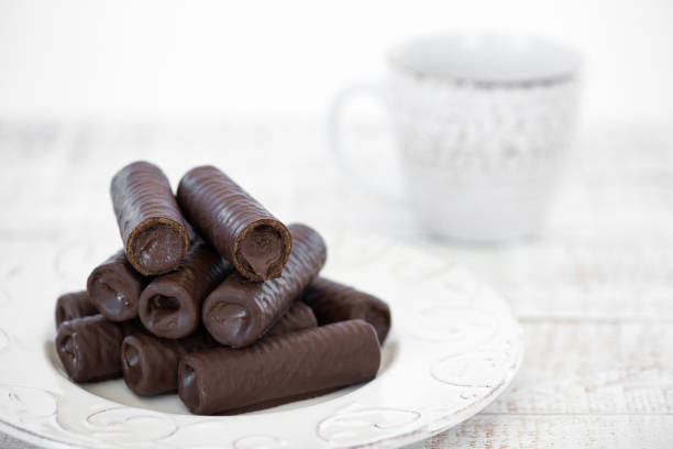 Sweet chocolate covered rolls - table arrangement, isolated on white background. Selective focus. Copy space.