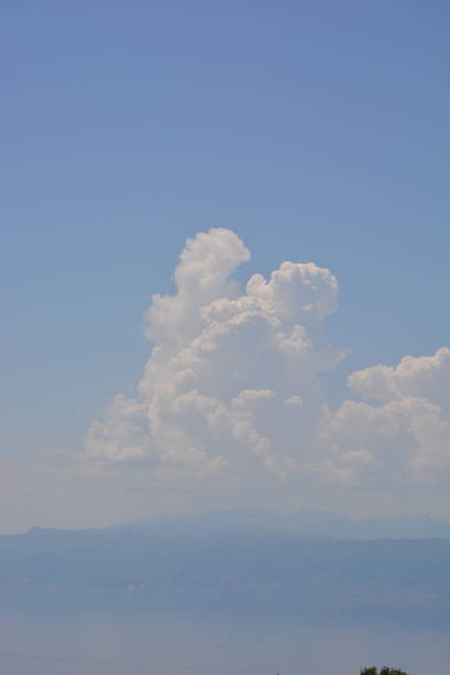On a hot and humid day, large stratocumulus clouds can be seen building over the Albanian side of the vast lake Ohrid.