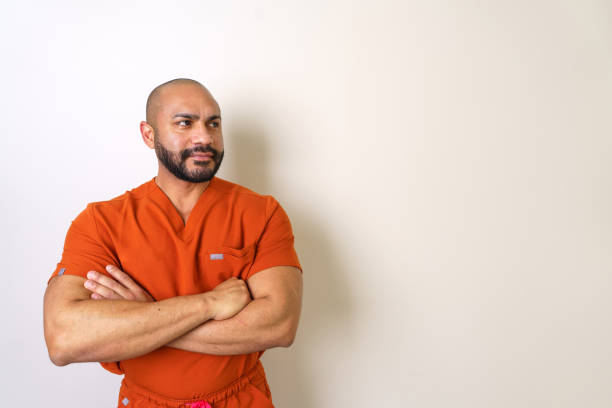 istock Confident male nurse posing with crossed arms on light background 2202302492