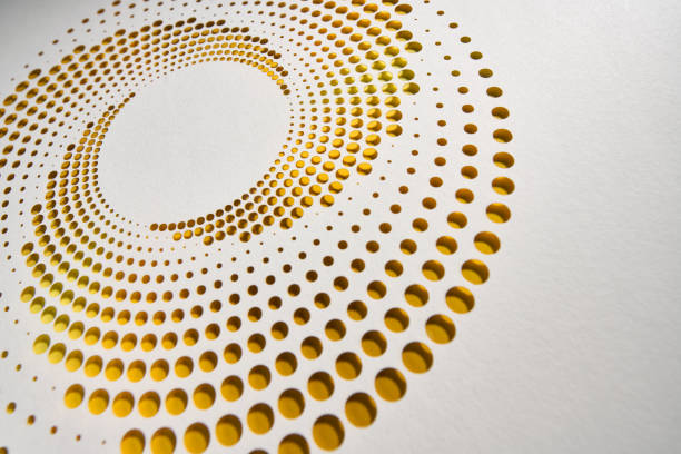 istock Intricate cut paper artwork with circular perforations forming a radial pattern in warm yellow and gold tones. 2202303745