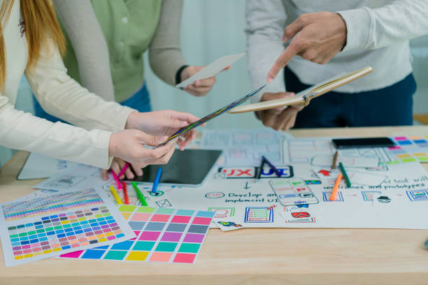 istock UX/UI designers discuss and brainstorm layouts for website and mobile app prototypes in website and application design ideas. Close-up. 2202304394