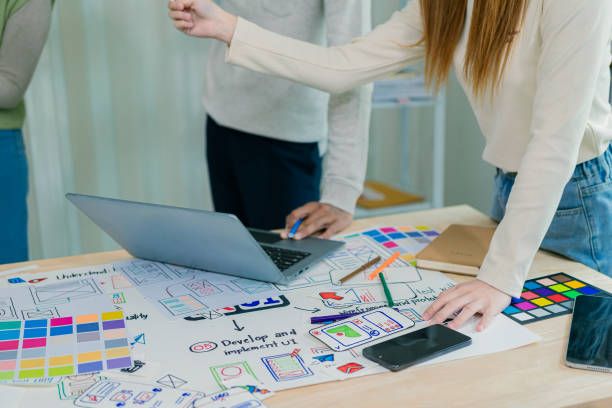istock UX/UI designers discuss and brainstorm layouts for website and mobile app prototypes in website and application design ideas. Close-up. 2202304428