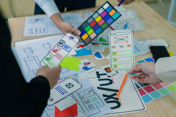 istock UX/UI designers discuss and brainstorm layouts for website and mobile app prototypes in website and application design ideas. Close-up. 2202304435