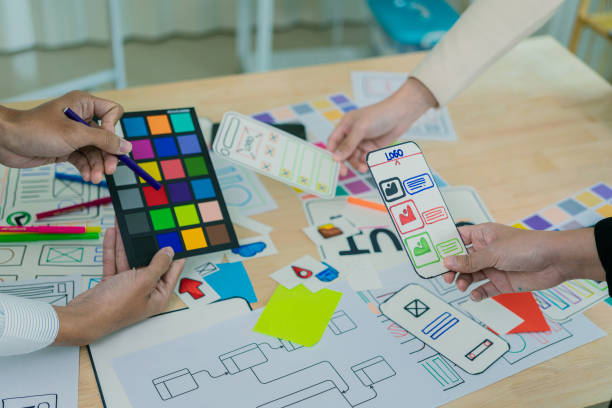 istock UX/UI designers discuss and brainstorm layouts for website and mobile app prototypes in website and application design ideas. Close-up. 2202304453