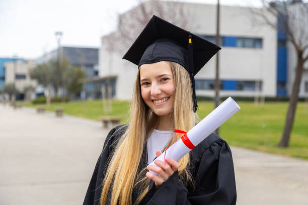 istock Happy graduate smiling and holding diploma in university campus 2202305784