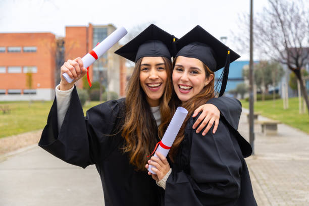 istock Two happy students celebrating graduation holding their diplomas 2202305793