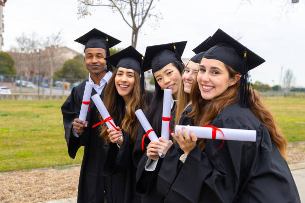 istock Happy multiethnic students celebrating graduation holding diplomas 2202305796